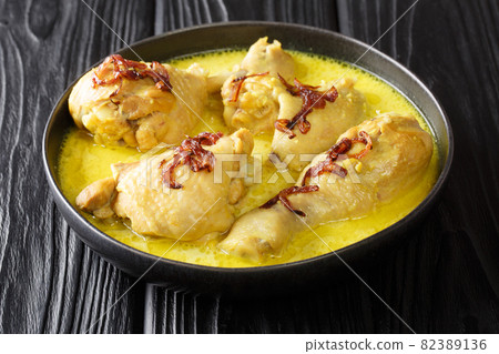 Indonesian chicken stew in coconut milk with spices close-up in a bowl. horizontal Indonesian chicken stew in coconut milk with spices close-up in a bowl. horizontal 82389136