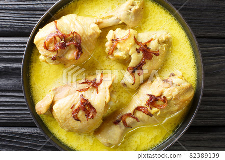 Opor ayam chicken cooked in coconut milk is one of many Indonesian dishes from Central Java close up in the bowl. Horizontal top view Opor ayam chicken cooked in coconut milk is one of many Indonesian dishes from Central Java close up in the bowl. Horizontal top view 82389139