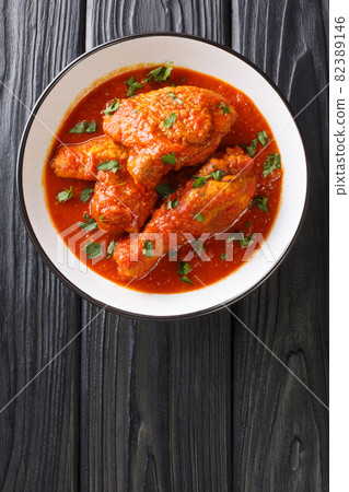 Ayam masak merah is a Malaysian traditional dish it is a casserole of chicken pieces in dried chillies sambal close-up in a bowl. Vertical top view Ayam masak merah is a Malaysian traditional dish it is a casserole of chicken pieces in dried chillies sambal close-up in a bowl. Vertical top view 82389146