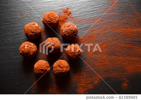 Chocolate homemade candy truffles laying on the slate background. Homemade cooking background with copy space 82389985