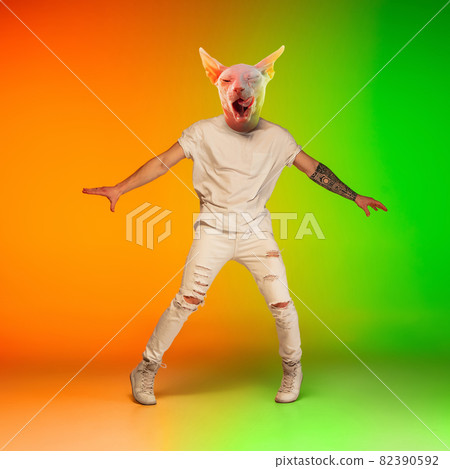 Contemporary collage with young man, hip hop dancer headed of cat's head dancing isolated over gradient yellow green background in neon light. 82390592