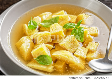 soup of chicken broth with parmesan egg dumplings 82390732