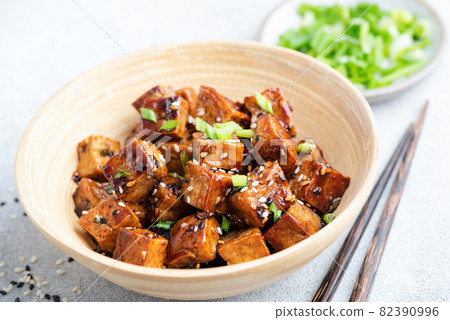 Fried tofu cubes with sauce and sesame seeds Fried tofu cubes with sauce and sesame seeds 82390996