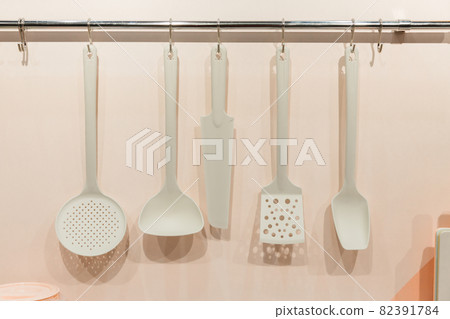 Kitchenware tools household goods plastic hang on the wall, kitchen interior in pastel trending colors 82391784