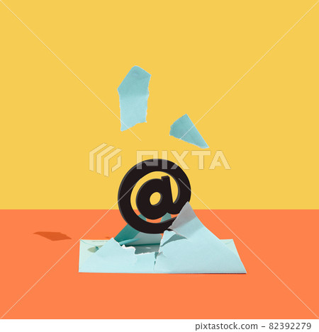 At, email sign, burst out of a blue envelope against orange and yellow background. 82392279