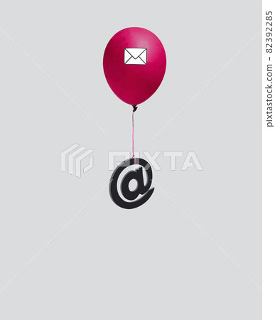 At, email sign hung on a red balloon with an envelope isolated on a light gray background. 82392285