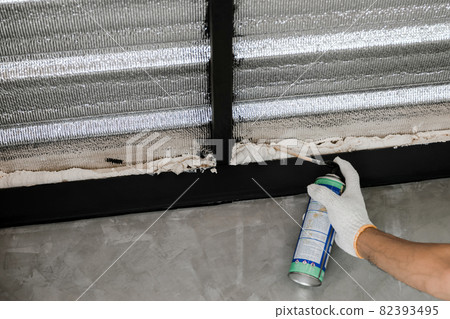 Human hand are caulking roof leaks with canned caulk foam. Human hand are caulking roof leaks with canned caulk foam. 82393495