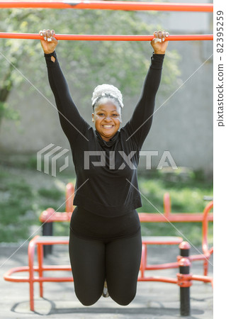 Afro-american plus size woman doing workout exercises session outdoor Afro-american plus size woman doing workout exercises session outdoor 82395259