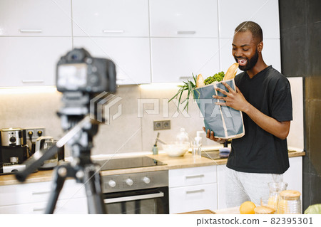 African male blogger recording vlog on digital camera 82395301