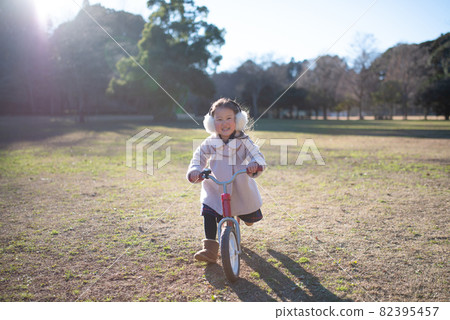 Girl playing on a bicycle Girl playing on a bicycle 82395457