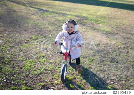 Girl playing on a bicycle Girl playing on a bicycle 82395459