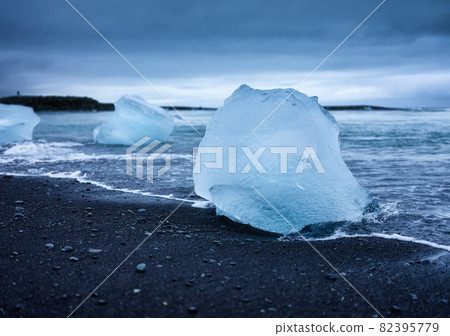 Diamond beach, Iceland. Ice on black sand on the beach. Ocean bay and icebergs. 82395779
