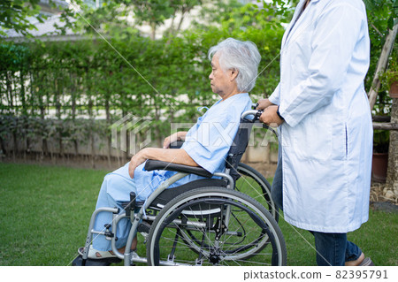 Doctor help and care Asian senior or elderly old lady woman patient sitting on wheelchair at park in nursing hospital ward, healthy strong medical concept. 82395791