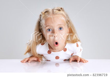 Portrait of little preschool girl posing isolated over white studio background. Funny facial expression Portrait of little preschool girl posing isolated over white studio background. Funny facial expression 82396719