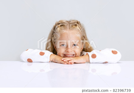Portrait of little preschool girl, child playing game isolated over white studio background. Portrait of little preschool girl, child playing game isolated over white studio background. 82396739