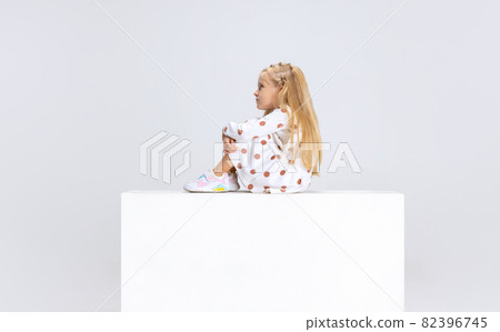 Side view portrait of little preschool girl sitting isolated over white studio background. Side view portrait of little preschool girl sitting isolated over white studio background. 82396745