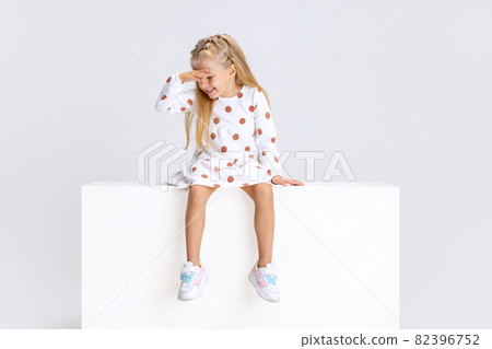Portrait of little emotive girl, child posing isolated over white studio background. Portrait of little emotive girl, child posing isolated over white studio background. 82396752