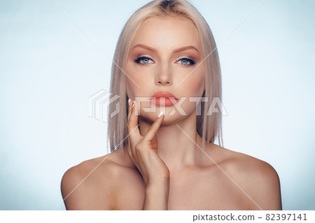 Close up beauty portrait of a blonde woman with perfect skin and plump lips Close up beauty portrait of a blonde woman with perfect skin and plump lips 82397141