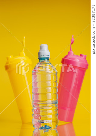 Pure water in plastic bottle on bright yellow background Pure water in plastic bottle on bright yellow background 82397173