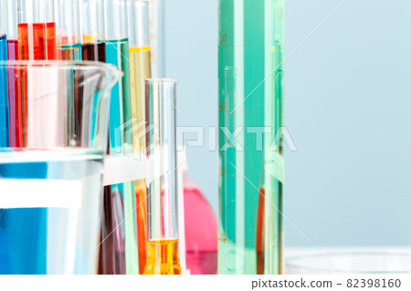 Colored liquids inside lab glassware on white table in laboratory 82398160