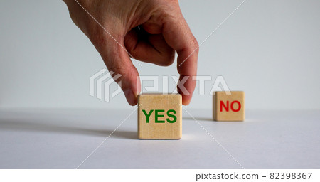 Hand making a choice between two cubes with 'Yes' and 'No' words on beautiful white background. Business concept. Hand making a choice between two cubes with 'Yes' and 'No' words on beautiful white background. Business concept. 82398367