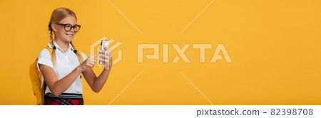 Cheerful smart european teen girl student in glasses makes photo on smartphone or calls online Cheerful smart european teen girl student in glasses makes photo on smartphone or calls online 82398708