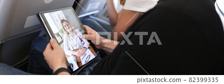 Man receives medical advice on video call while sitting on airplane Man receives medical advice on video call while sitting on airplane 82399335