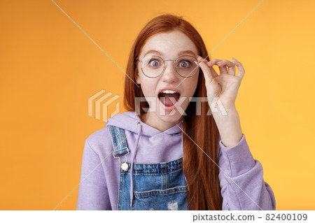 Omg so cool. Portrait amazed speechless excited redhead girl drop jaw amused stare camera surprised find out awesome product net touch glasses reading impressive post, orange background Omg so cool. Portrait amazed speechless excited redhead girl drop jaw amused stare camera surprised find out awesome product net touch glasses reading impressive post, orange background 82400109