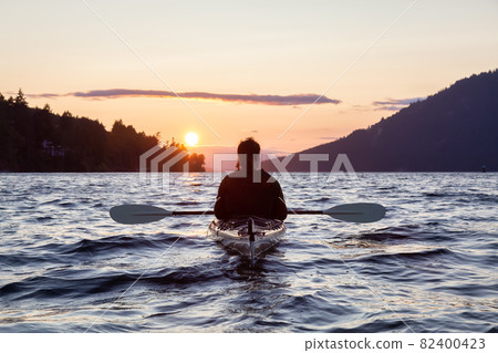 Adventurous Woman on Sea Kayak paddling in the Pacific Ocean. Adventurous Woman on Sea Kayak paddling in the Pacific Ocean. 82400423