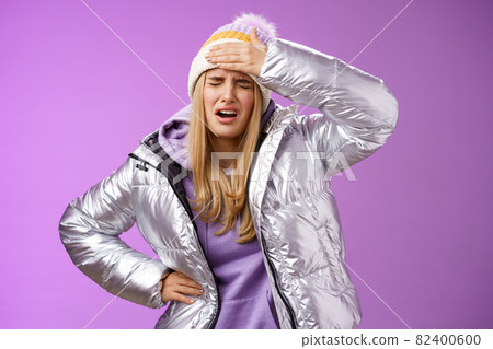 Girl sick tired touch forehead painful feeling grimacing complaining boyfriend shot snowball woman face standing bothered fed up and upset, whining displeased suffering headache, purple background 82400600