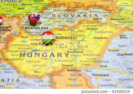 National flag Hungary pinned on political Europe map. Macro Close up picture on a colorful and blurry world atlas with capital country - Budapest. Push pin marker of destination. 82400839