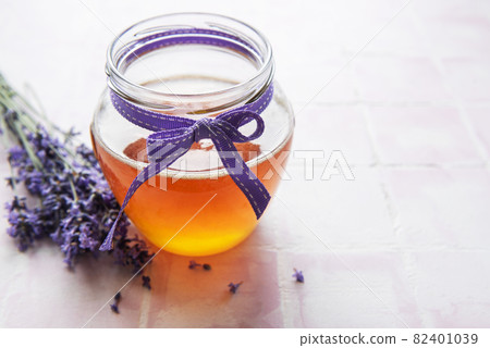 Jar with honey and fresh lavender flowers 82401039