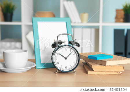 Office interior details with alarm clock and stationery items 82401394