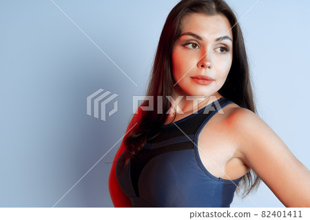 Healthy fit young woman in sportswear standing over a gray background Healthy fit young woman in sportswear standing over a gray background 82401411