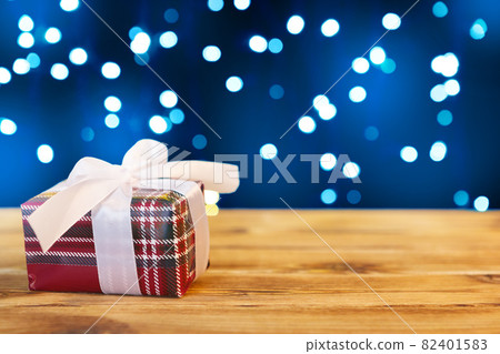 Small christmas gift boxes on wooden table against bokeh lights background Small christmas gift boxes on wooden table against bokeh lights background 82401583