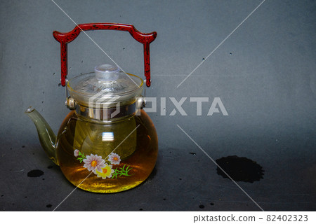 A kettle next to pressed green tea with mint. A kettle next to pressed green tea with mint. 82402323