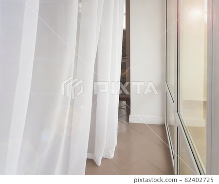 Side view of a huge panoramic window with a transparent white curtain, modern interior of apartments in a luxury hotel 82402725