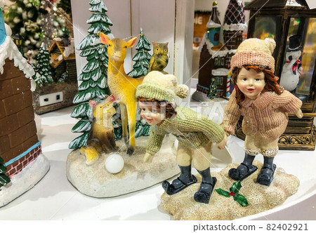 Elves, Reindeer and Santa Claus with bag standing near Christmas tree opposite Elf Club House Elves, Reindeer and Santa Claus with bag standing near Christmas tree opposite Elf Club House 82402921
