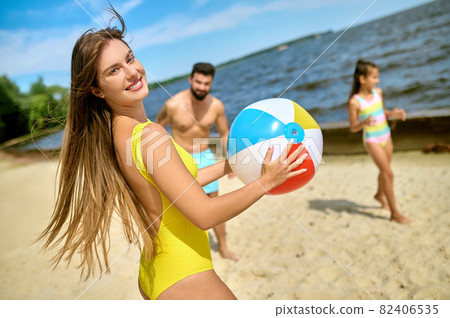 A family playing beach volleyball and feeling happy 82406535