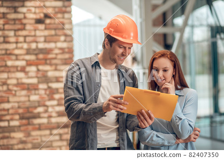 Smiling man and woman looking at sketch Smiling man and woman looking at sketch 82407350
