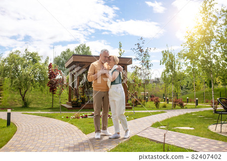 Loving husband hugging his female spouse outdoors 82407402
