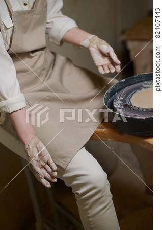 A female potter in her workshop looking involved in the process of pottery A female potter in her workshop looking involved in the process of pottery 82407443