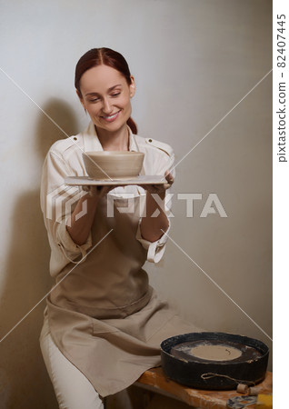 A female potter in her workshop looking involved in the process of pottery A female potter in her workshop looking involved in the process of pottery 82407445
