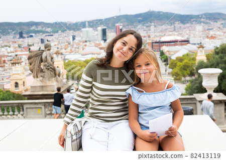 Young woman tourist hugs with daughter in the city center Young woman tourist hugs with daughter in the city center 82413119