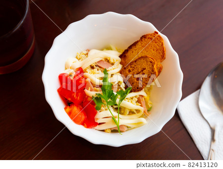 Salad of cabbage, eggs, sausages and mayonnaise with toasted baguette Salad of cabbage, eggs, sausages and mayonnaise with toasted baguette 82413120