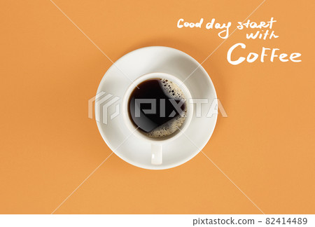 Top view of cup of black coffee and Good day start with Coffee lettering isolated on orange background 82414489