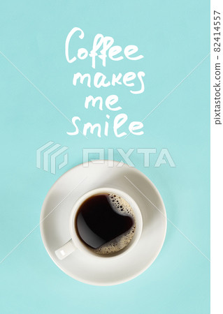 Top view of cup of black coffee and Coffee makes me smile lettering isolated on blue background 82414557