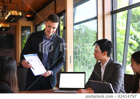 Businessman holding documents and presenting new project to business partners in modern office. Businessman holding documents and presenting new project to business partners in modern office. 82414797
