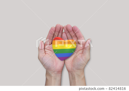 LGBTQ rainbow heart in hands on white background. 82414816