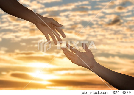 Giving a help hand concept. Reaching hand helping, hope and support each other over sunset Giving a help hand concept. Reaching hand helping, hope and support each other over sunset 82414829